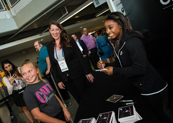 Simone Biles signs autographs before the competition